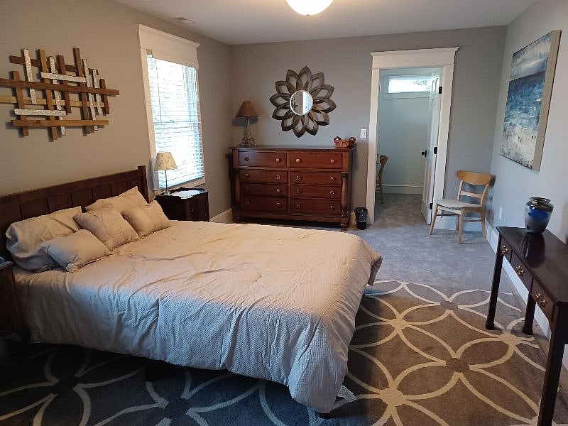 The front bedroom has a queen size bed and dresser with a large closet area that includes a desk and chair.