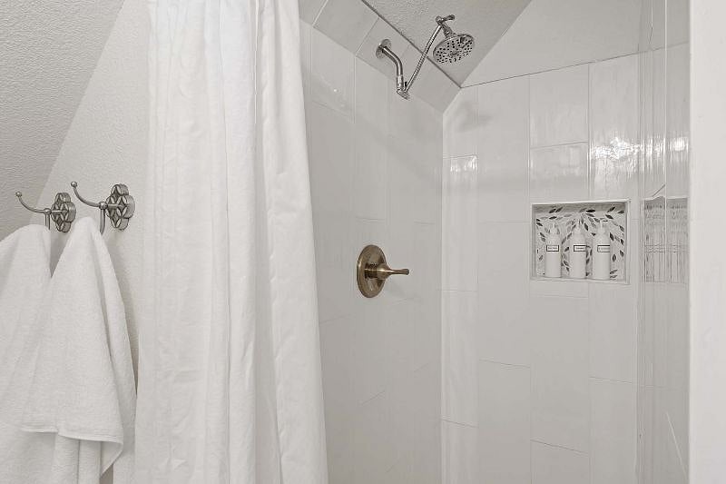 Brand new shower with river stone floor and shampoo niche for a spa like feel.