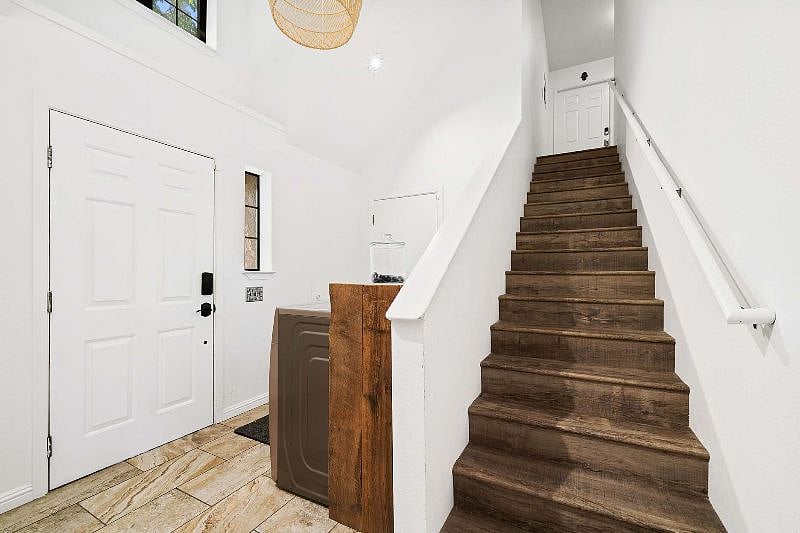 Stairway up to 2 separate units, Washer and dryer on left.