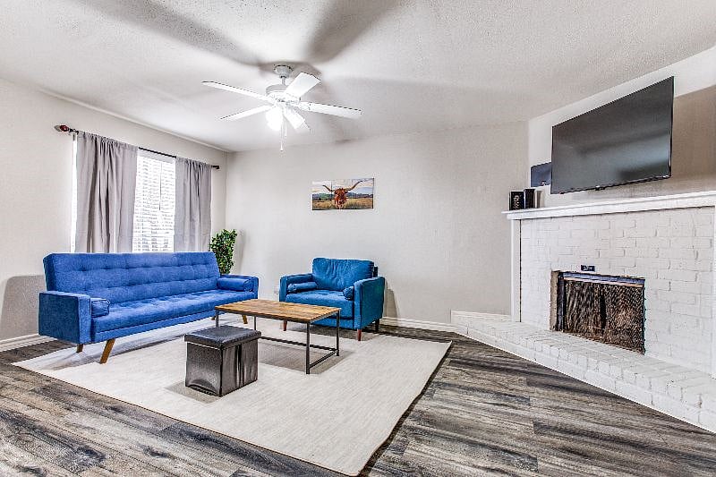 Unwind on the Cozy Blue Sofa & Armchair by the Fireplace While Watching Your Favorite Movie