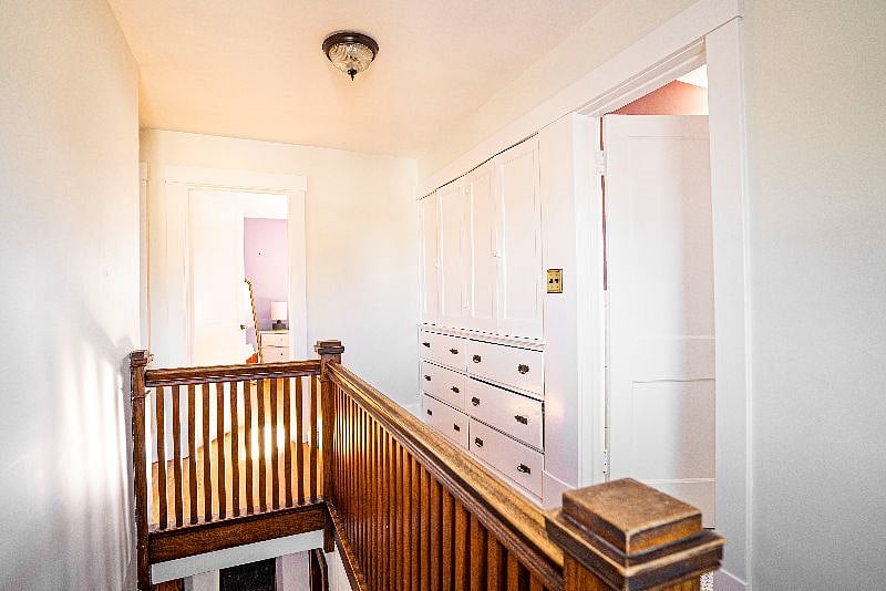 Original built-in dresser and wood banister