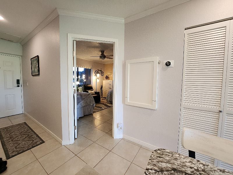 View to the 2nd bedroom and front door, fold-down desk/table, and w&d cleaning supply closet.