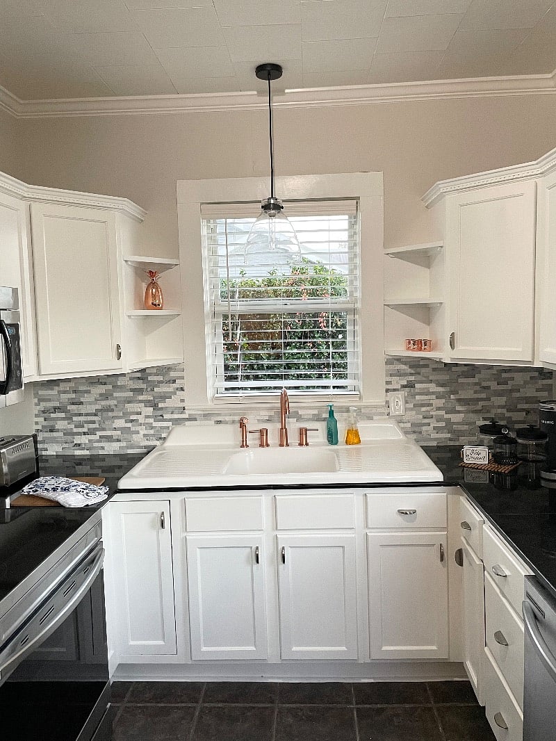 Restored 1950s original cast iron sink with copper fixtures. Stone backsplash in relaxing gray tones.