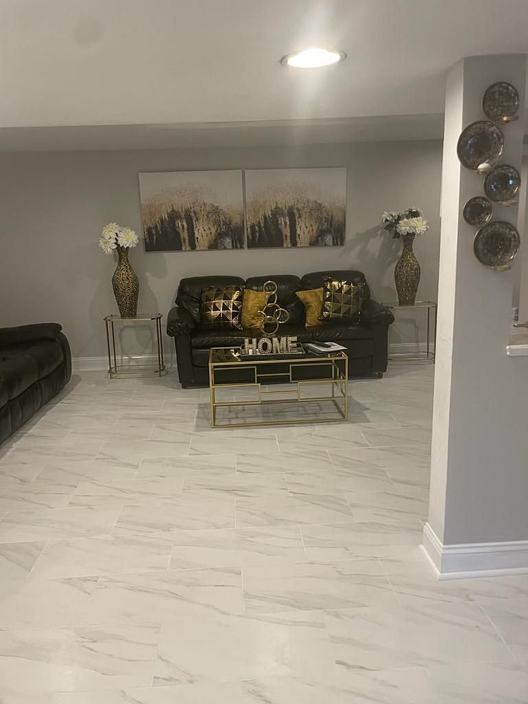 View of living room. Floor was recently updated with beautiful porcelain tile for a modern appeal and ease of use.
