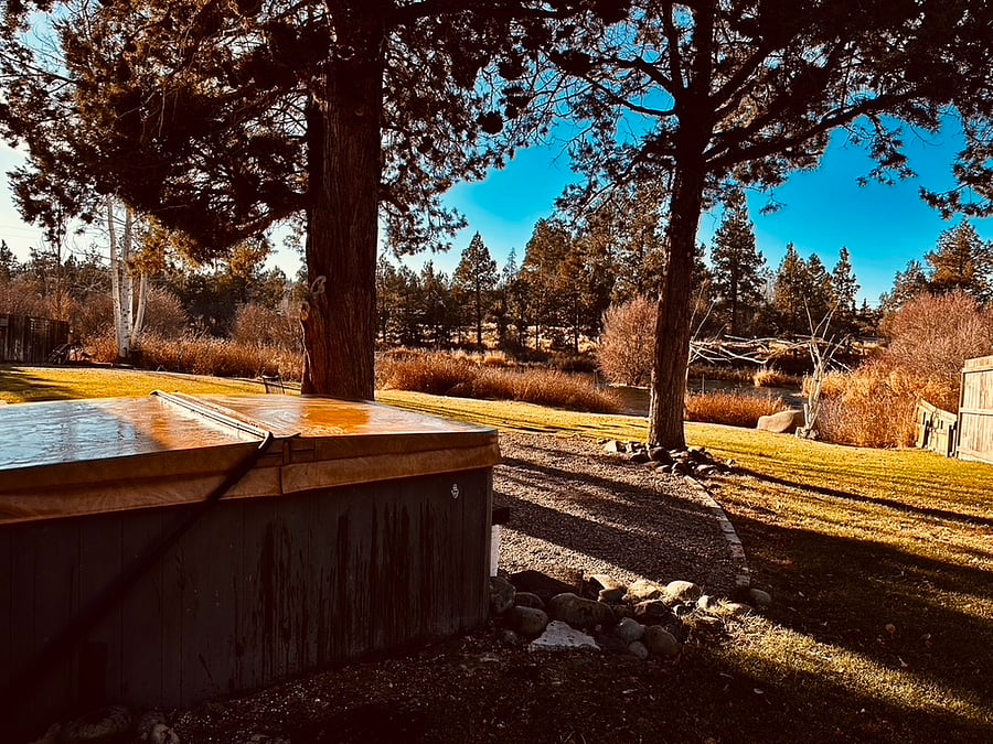 Hottub and hammock and seating area with 4 seat conversation table setting outside of slider doors