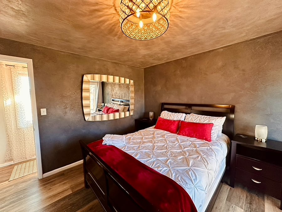 Queen bedroom with bathroom and sliding doors to the hot tub