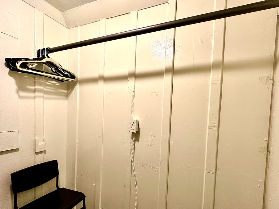 Spacious walk-in closet off the living room with shelving, area to hang clothes and storage
