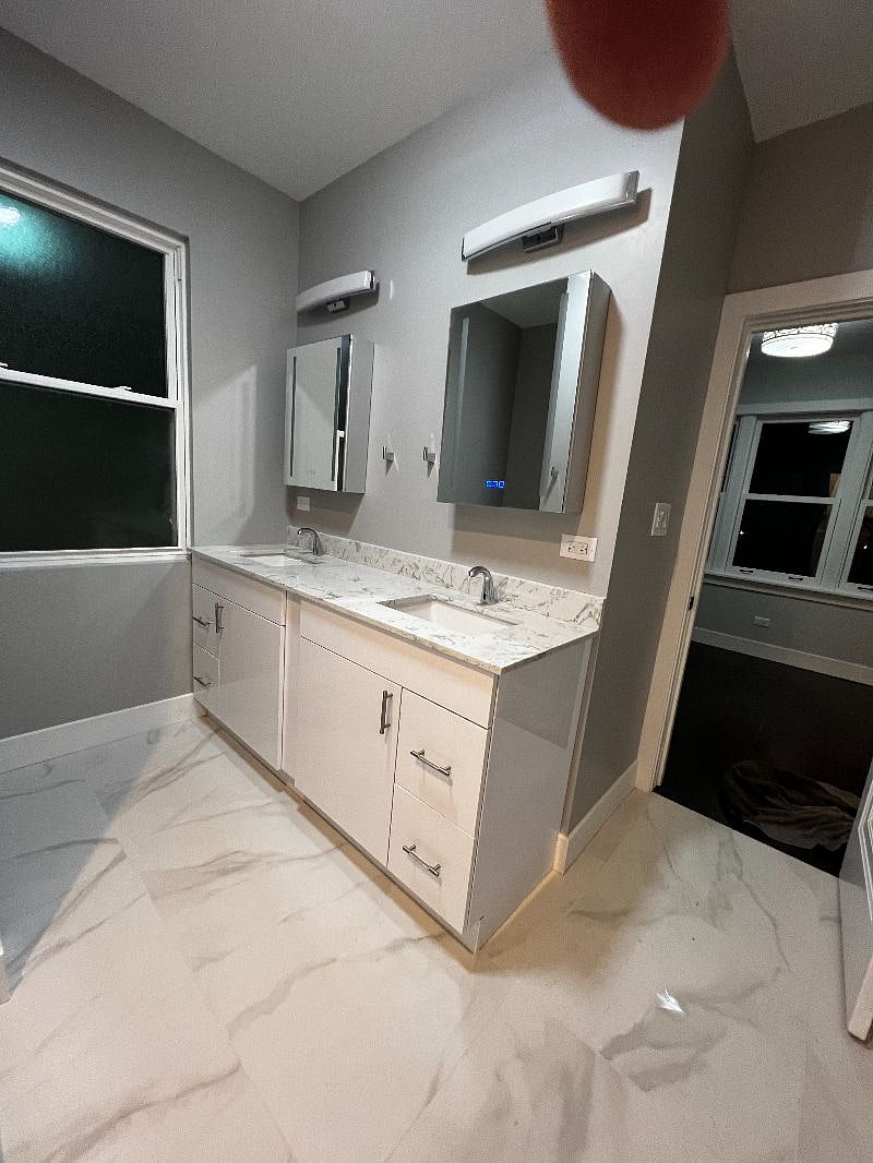 Primary Bath with Double Sinks, lighted, dimming, and de-fog mirrors, dual-flush toilet.