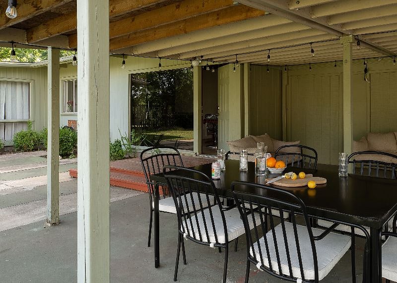 The rear covered patio includes a propane grill, 6-seat dining area, and lounge seating.