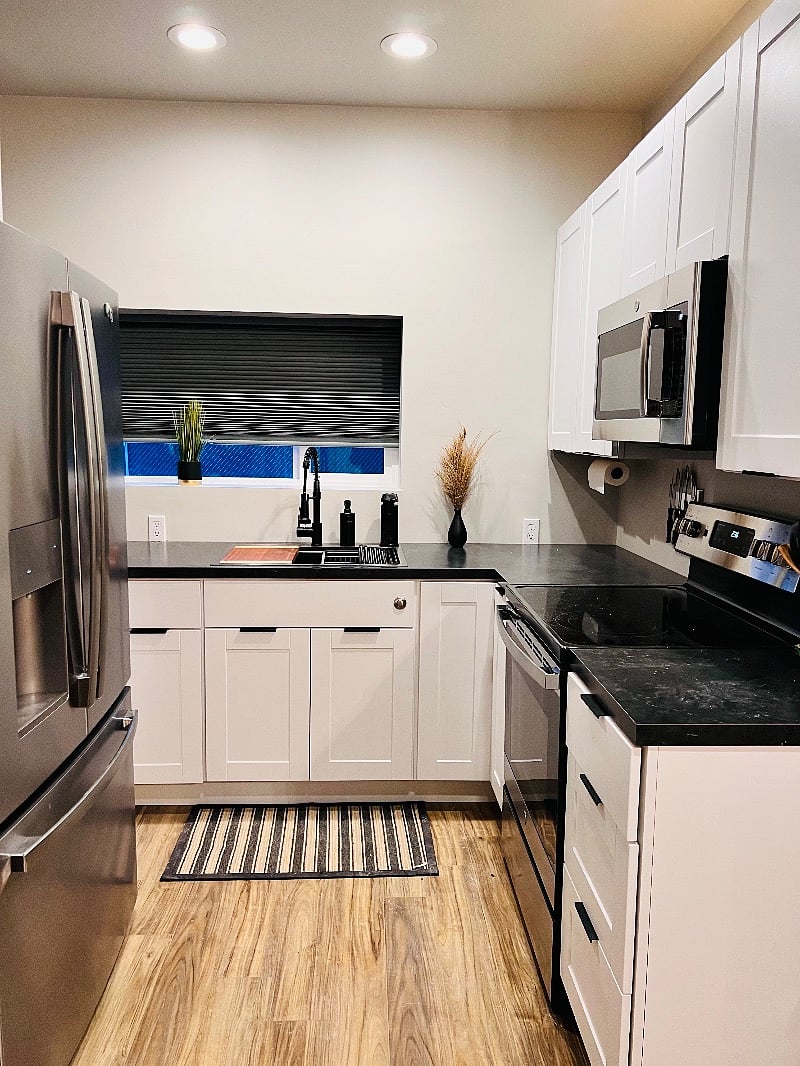 large sink, stove, microwave, full size refrigerator, oven includes air fryer. Kitchen is fully stocked with spices, coffee station, cooking spray, utensils, cleaning supplies,