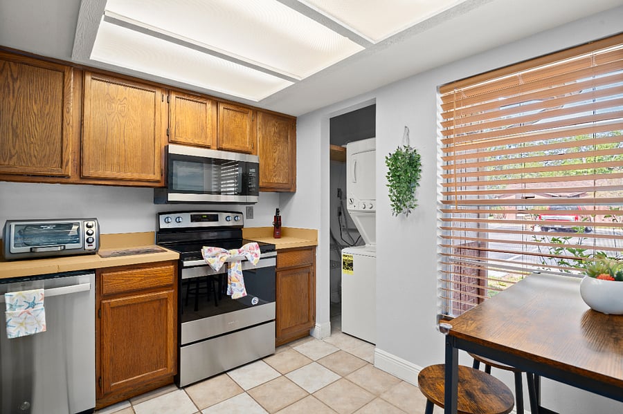 Whip up meals in this fully equipped kitchen featuring a charming and  cozy eat-in dining nook, perfect for morning coffee or family dinners