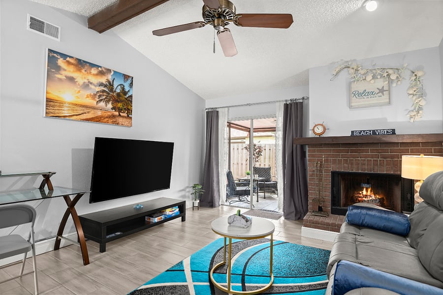 This bright and spacious living room features a 65" Smart TV, cozy recliner, board games, and  a full size work desk with supplies.