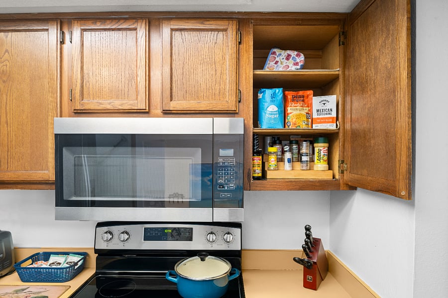 Microwave, full-size stove, cutely, assorted quality pots & pans, and a variety of starter spices and oil.