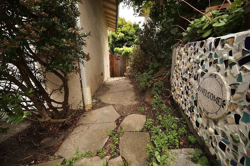 Walkway with flagstone steps on a downward slope to the apartment.