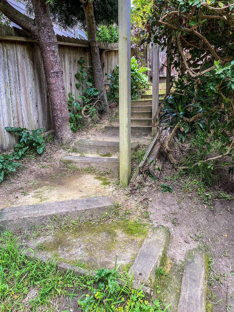 Approximately 15 wooden railroad trestle steps down a fairly steep hill to reach the private apartment entrance.
