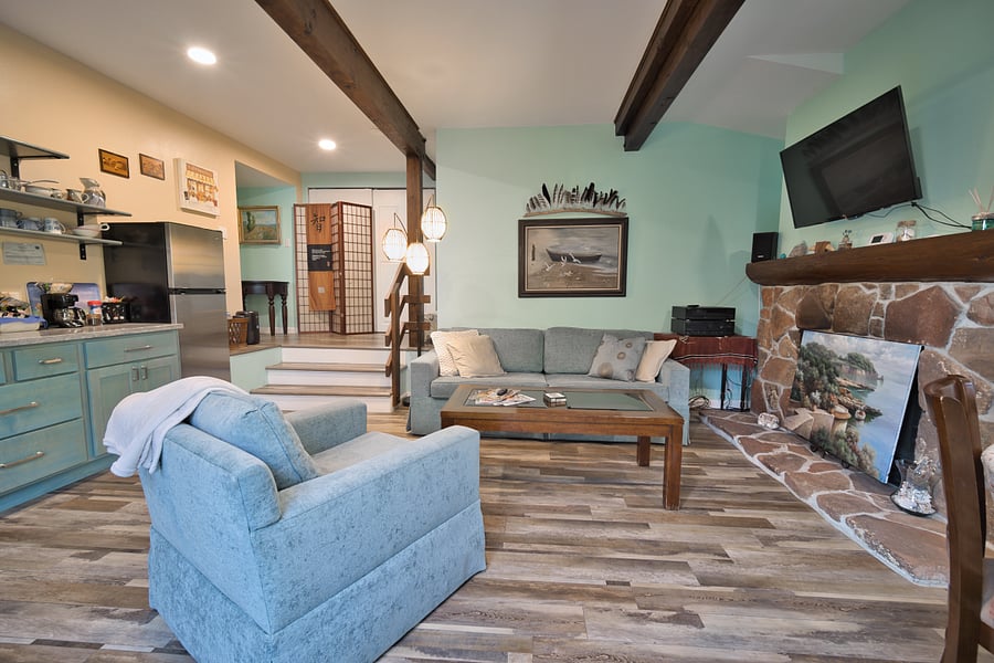 The main living room area. There is a swivel wall mounted tv above the fireplace. (Note the fireplace is non-operational).