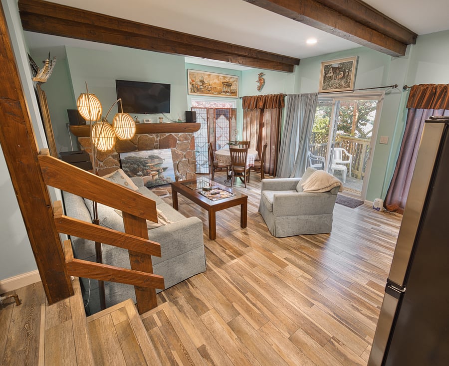 Step down into the main living space. Four large picture windows allow ample light with private outdoor garden and patio views.