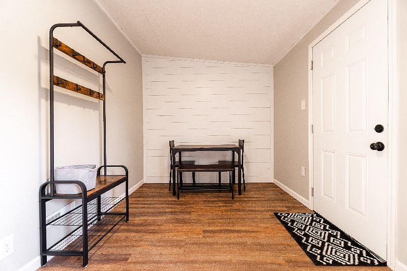 Back room with exit to back yard. Table and seating for 4 as well as shoe and coat storage.