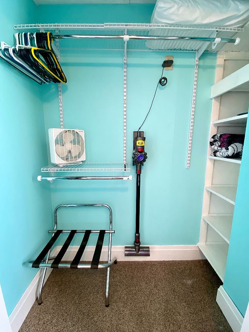 Bedroom with queen sized bed, blackout curtains, closet and dresser