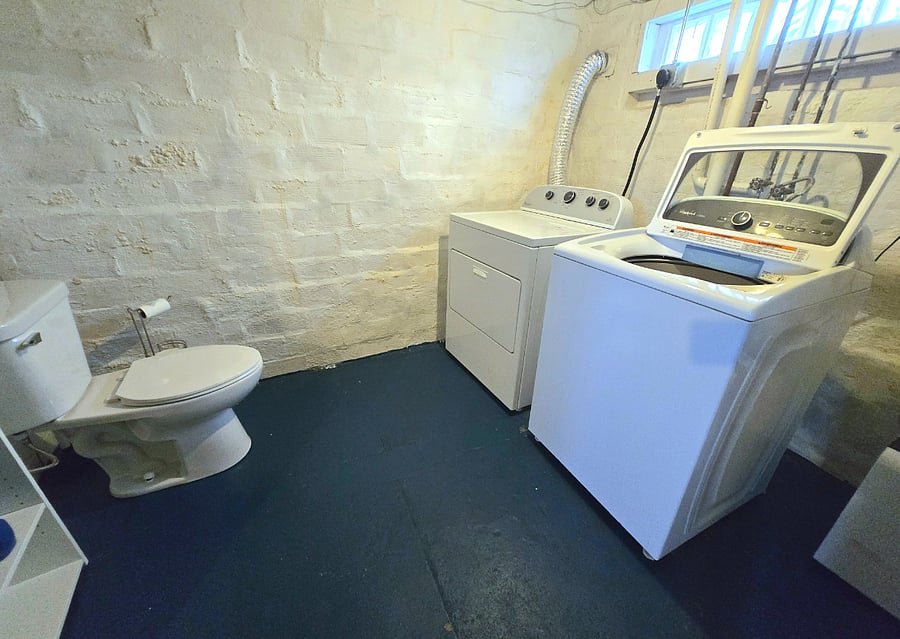 Laundry area and half bath located in basement