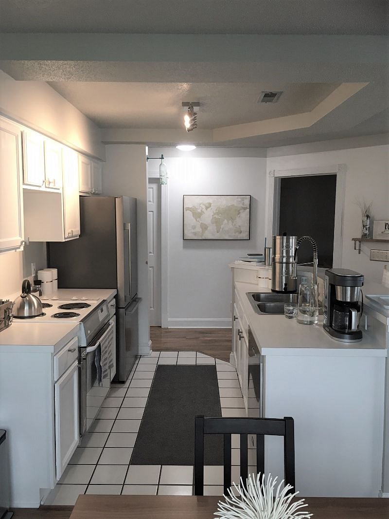 Well-stocked bright functional kitchen with stainless appliances and quiet dishwasher.
