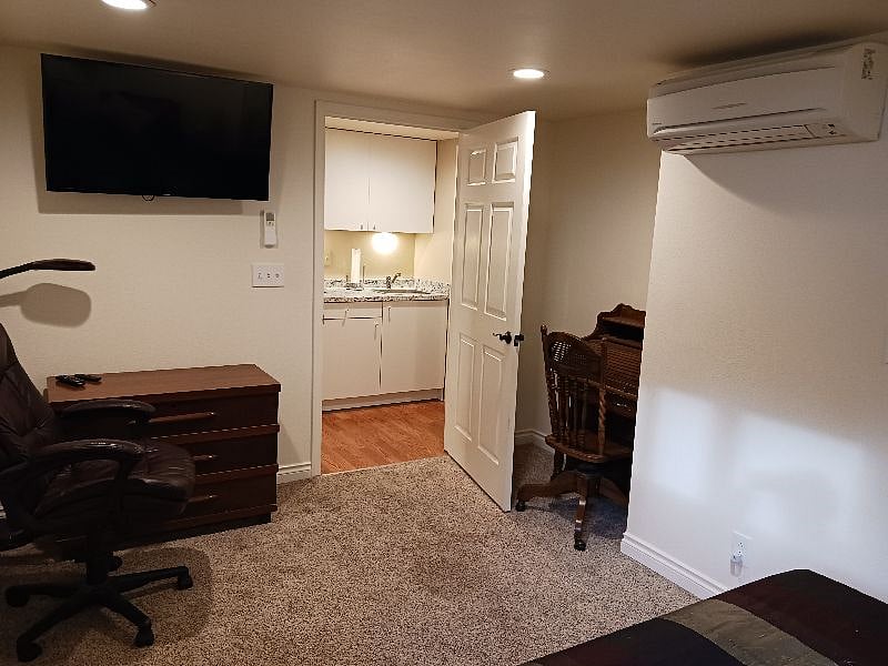 Door to hallway/kitchen, Ductless heat/AC unit, desk in bedroom