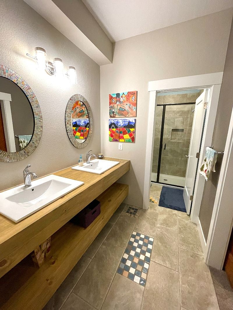 Private bath with 2 sinks and walk in shower. The shower has its own separate lockable door and the toilet also has its own separate lockable door.