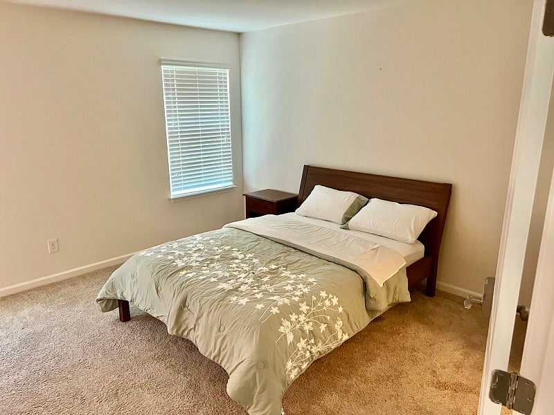 Large upstairs bedroom with 2 walk-in closets and private bathroom, including shower/tub and double vanity sink.