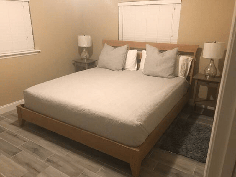 Quality solid wood king size Ethan Allen bed with clean soft linens for a peaceful nights sleep.