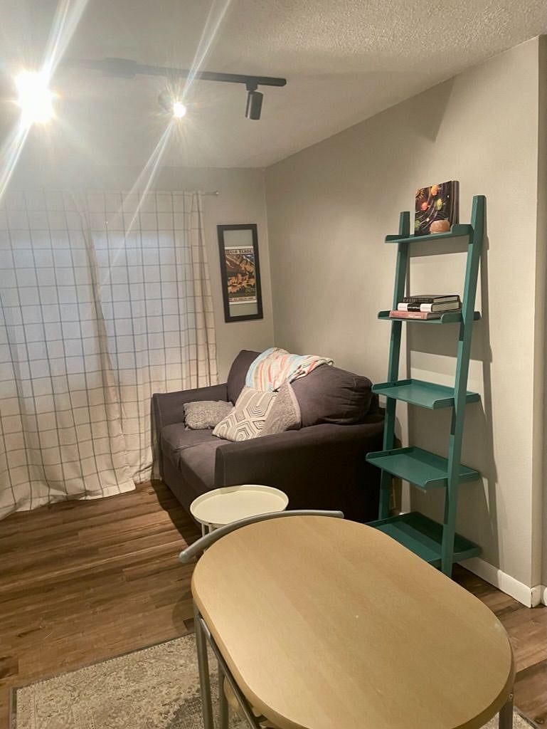 The downstairs living area also features a smart TV, a comfy oversized chair, and plenty of shelving/storage. 