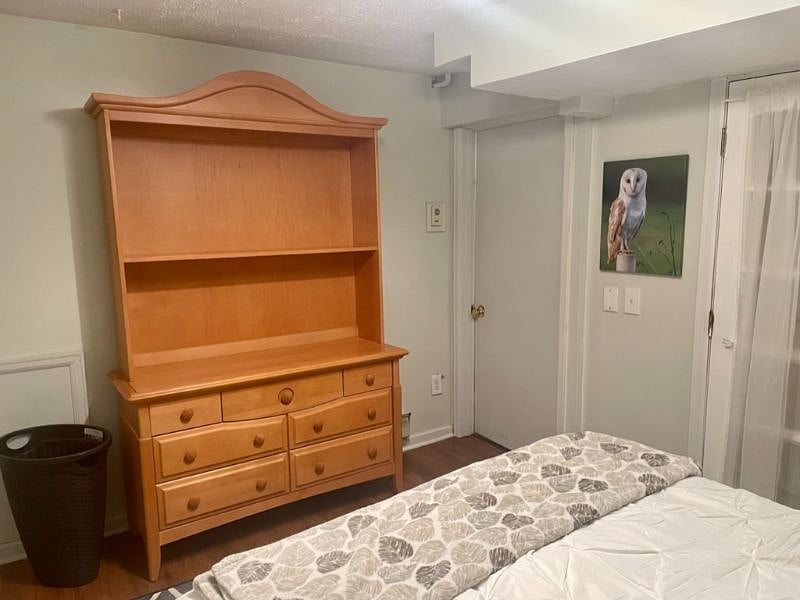 The downstairs bedroom features a large dresser with shelving.