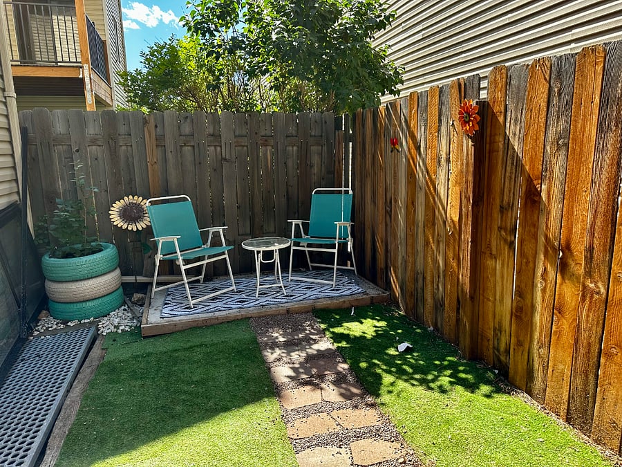 There is a private backyard with a six-foot fence that features two sitting areas -- this one that can be sunny in the AM. Astroturf is ideal for dogs as it is easy pickup!