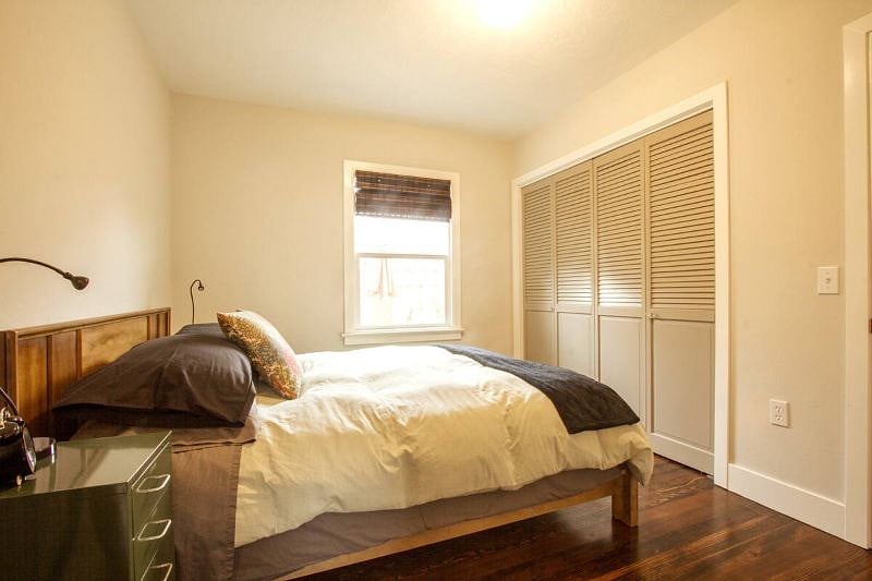 The large closet is filled with lots of shelving and hanging space and also stores an iron and a full sized ironing board.