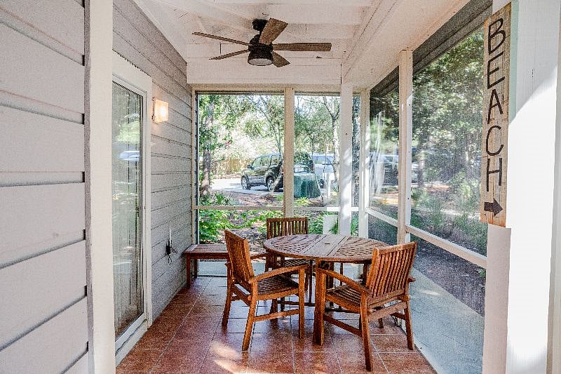 A screened in patio that stretches the length of the unit nestled in beautiful lush landscaping