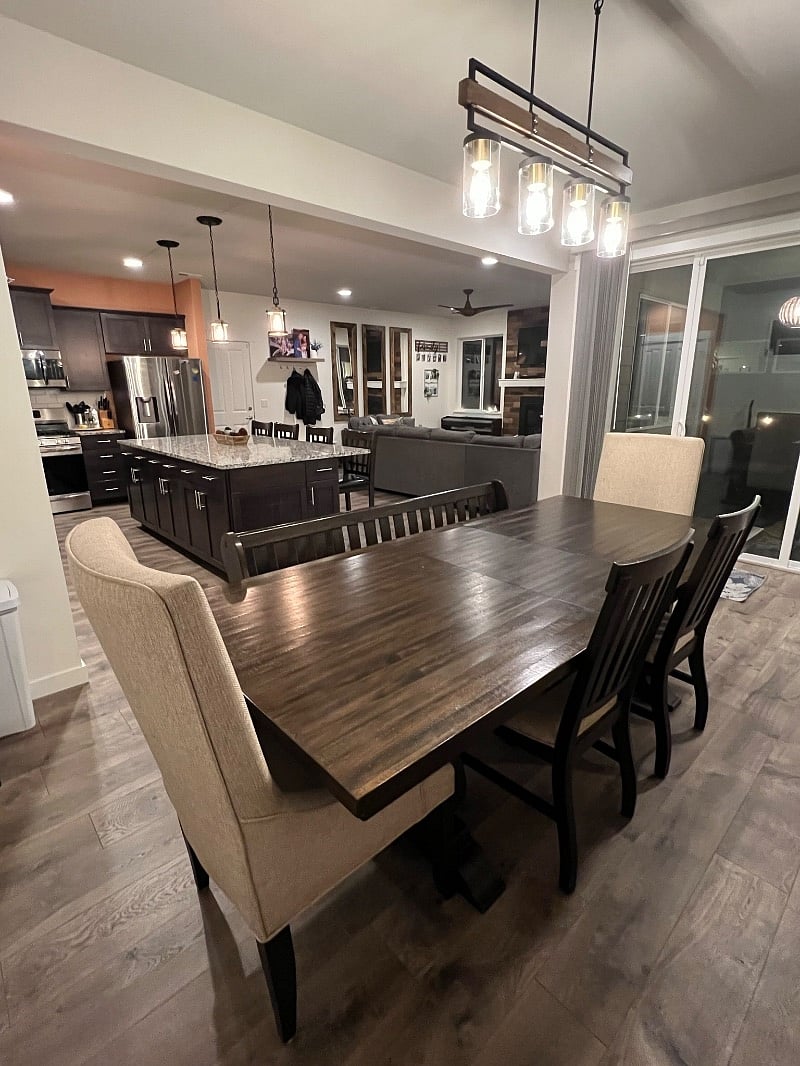 Dining table w/ seating for 7, kitchen w/ island and seating for 4, and shared living room.