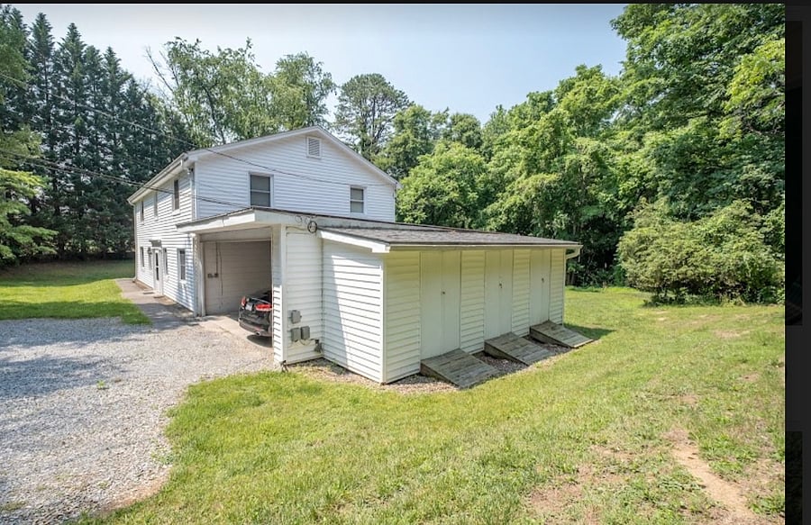 Side view of house showing parking area and designated extra storage area in addition to unit.