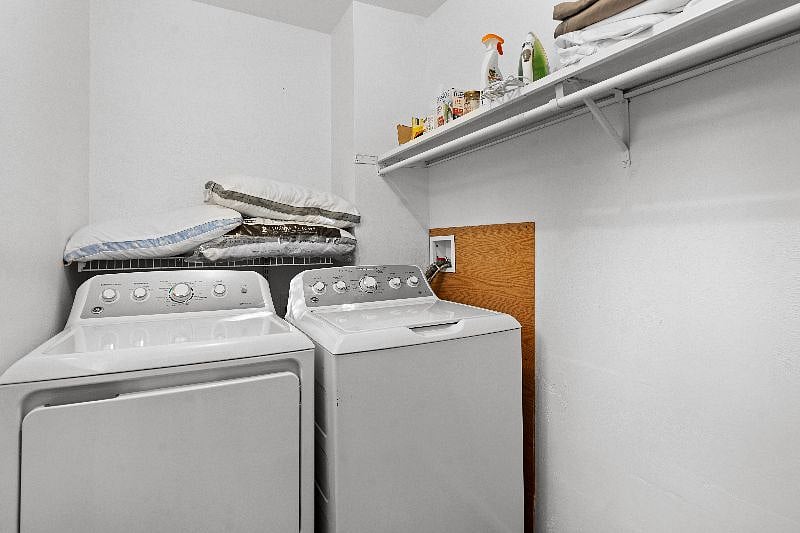 Laundry room shows full washer and dryer and extra pillows should you need them.