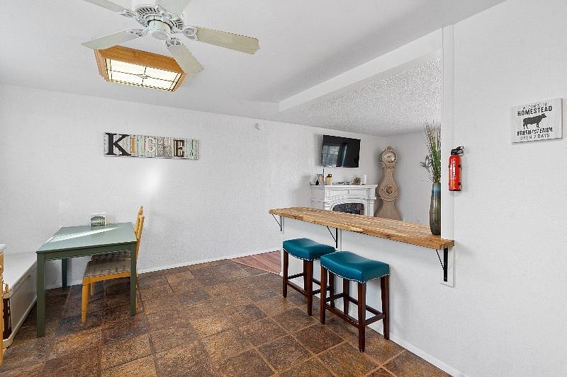 Shows eat-in bar area overlooking TV and kitchen table.