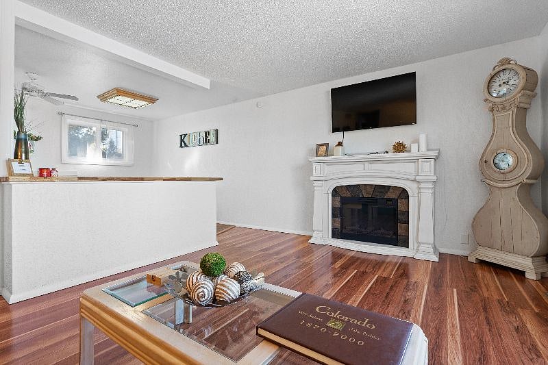 Living area features flat screen TV and electric fireplace.