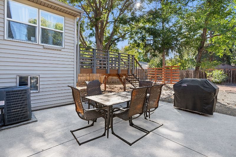 Outside patio, outdoor table and chairs and BBQ in foreground. Private deck in background.