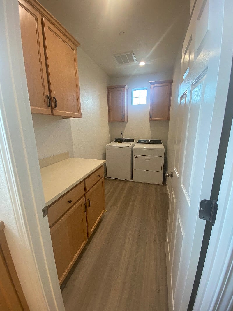 Laundry room is to the right of the stair well. Spacious and able to store ironing board and vacuum if needed along with clothes hampers, etc. Brand new machines, lots of cabinets, drawers and counter space.