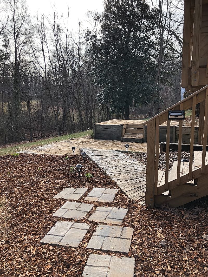 walkway with night security lights leads to deck and patio area at entry to studio