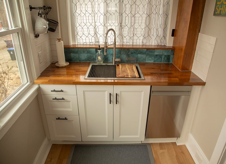 Kitchen sink workstation includes compact dishwasher