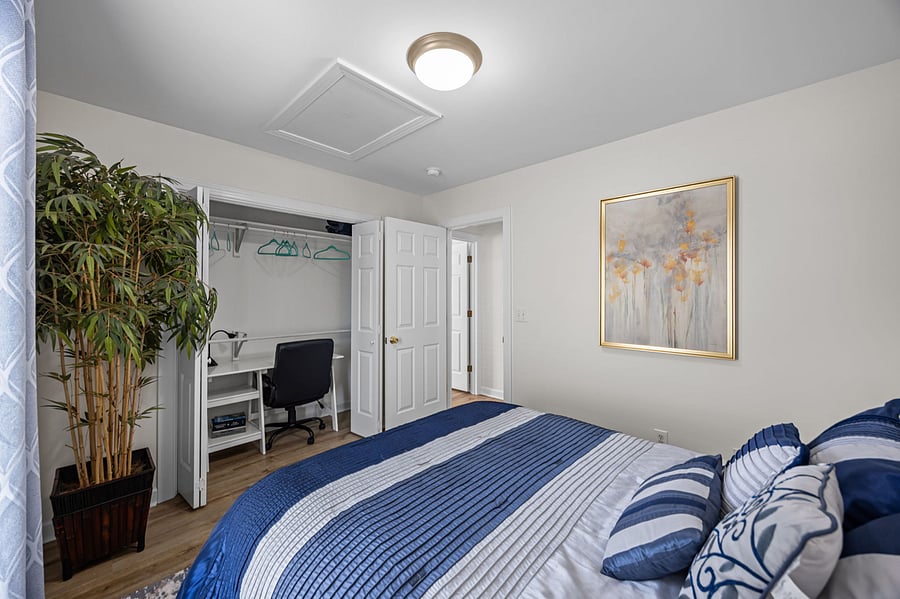 This secondary bedroom has a surprise - a hidden desk offers a quiet and convenient office space.