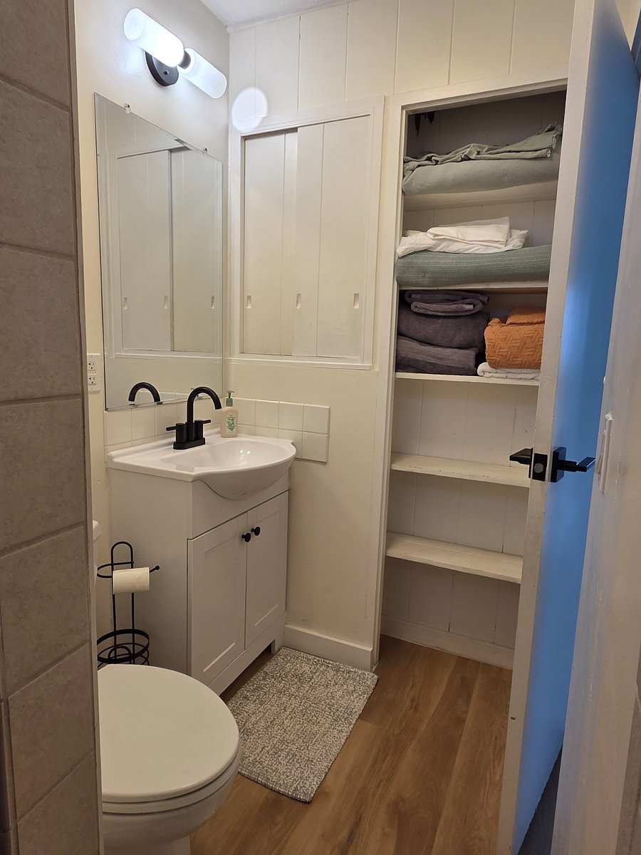 Plenty of storage in this full sized bathroom with a medicine cabinet and shelf space. 