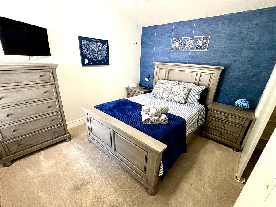 The second bedroom includes a queen bed, TV, dresser, and room to feel at home.