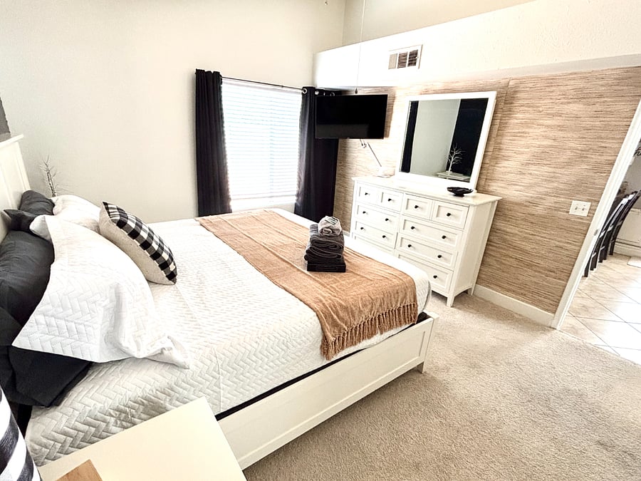 A king bed, dresser, and TV create a comfortable private retreat.