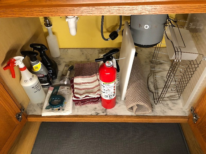Cleaning supplies, dish drain, etc. under kitchen sink.