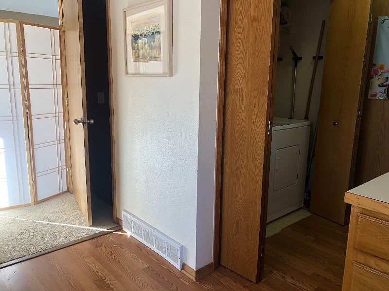 Entryway to apartment door. Solid wood door ensures quiet. Newly carpeted and well-lit stairs down.