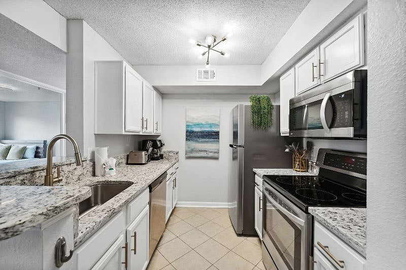 Fully updated fully stocked kitchen with new fridge, stove, dishwasher, stone countertops and gold accents. All new kitchenware and flatware.